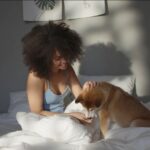 Frau mit Hund im Bett