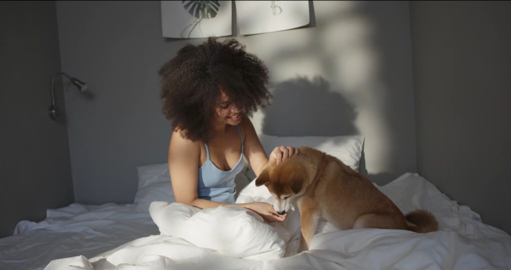 Frau mit Hund im Bett